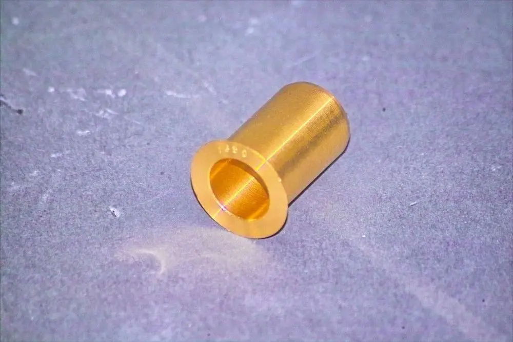 Goldfarbener Metallzylinder mit einer Öffnung an einem Ende, auf einer grauen Oberfläche liegend. Gehörte zu einem Brötje Heizsystem.