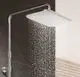 Duschsystem mit quadratischem Kopfbrause, Wasserlauf und chromfarbener Oberfläche, montiert an einer Wand, in einem modernen Badezimmer. Hersteller Kludi.