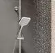 Kludi-Duschsystem mit einem verstellbaren Handbrausekopf, der über ein Thermostat verbunden ist. Wasserstrahlen spritzen von der Duschkopf-Aussenseite in den Raum.