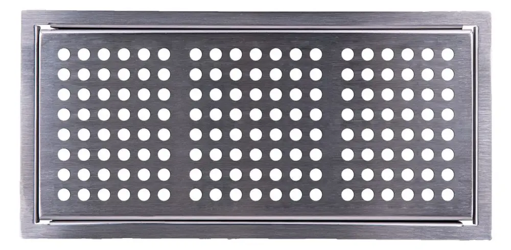 Edelstahl-Abdeckgitter mit kreisförmigen Löchern. Das Produkt stammt von der Marke Pluggit und bietet eine funktionale Verarbeitung für Bereiche mit Luftzirkulation.