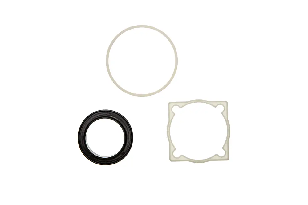Dichtungen von Brötje in verschiedenen Formen: ein schwarzes O-Ring, eine helle Dichtung im Kreis und eine rechteckige Dichtung mit runden Öffnungen.