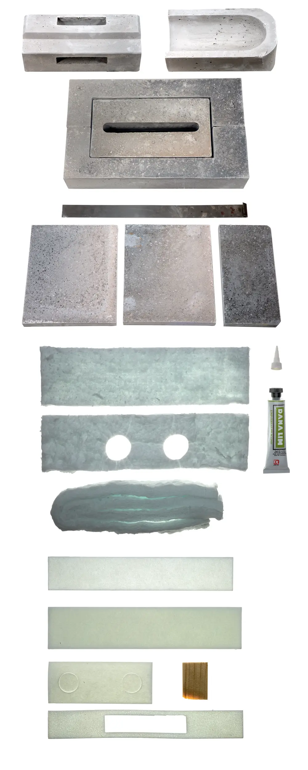 Brötje Stein-Set mit verschiedenen Betonsteinen und transparenten Platten, sowie Kleber. Anordnung der Elemente zeigt verschiedene Formen und Oberflächen.