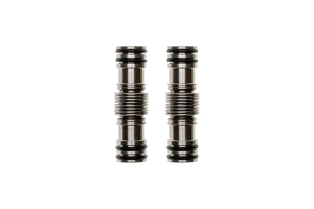 Zwei verchromte, zylindrische Bauteile mit Rillen und O-Ringen, liegend auf weißem Hintergrund. Teile könnten als Zubehör für Brötje Produkte dienen.
