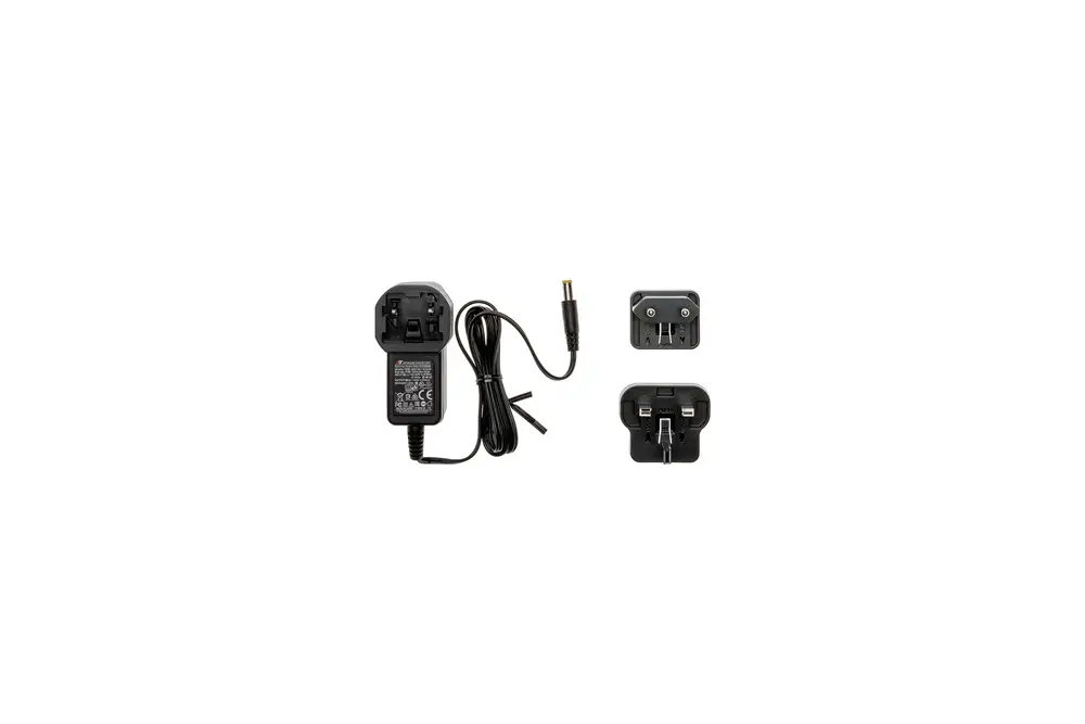 Netzteil mit wechselbarem Stecker für Brötje Produkte. Elektrisches Kabel mit Anschlussbuchse. Adapter für verschiedene Steckdosenformate abgebildet.