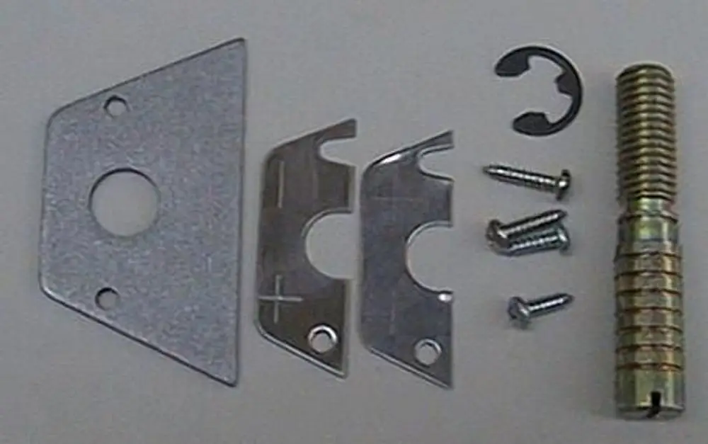 Befestigungsteile von Brötje, bestehend aus Metallplättchen, Schrauben, einer Feder und einer Sicherungsring, angeordnet auf hellem Hintergrund.
