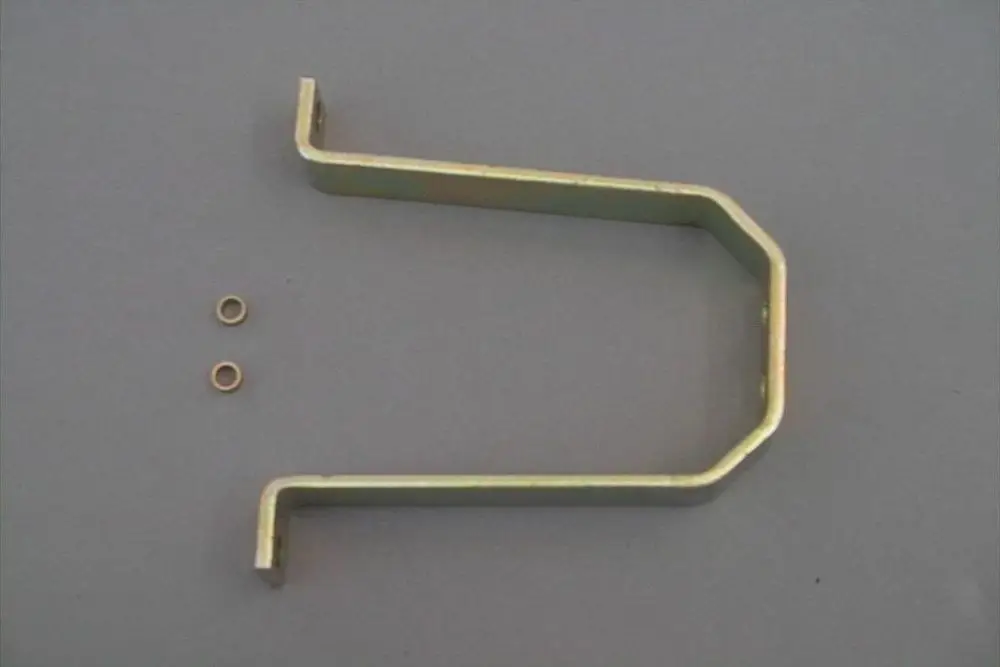 Halter aus Metall mit gebogener Form und zwei kleinen Ringen, hergestellt von Brötje. Der Halter liegt auf einer grauen Unterlage.