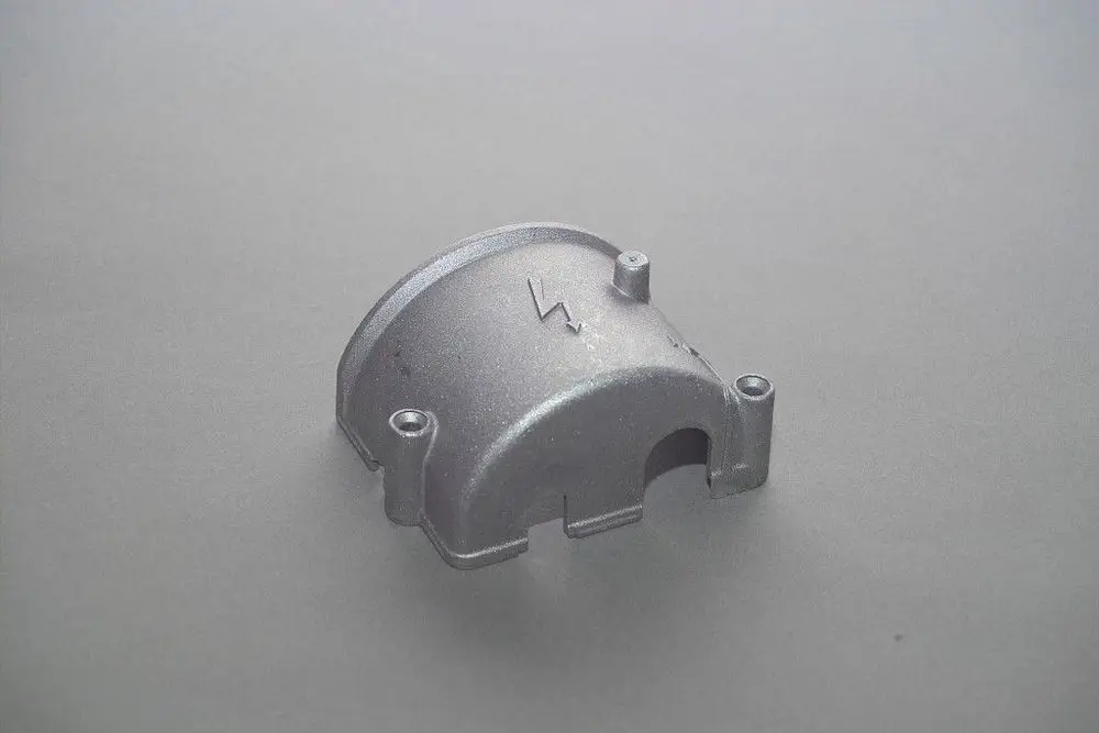 Metallischer Deckel von Brötje mit zwei Befestigungspunkten und einer Öffnung. Die Oberfläche ist glatt und in einem grauen Farbton gehalten.