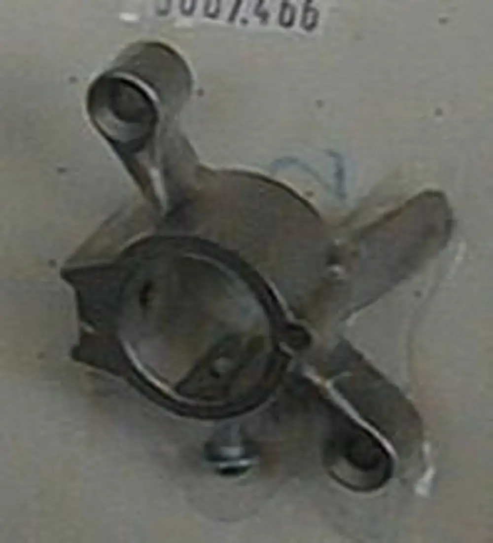 Brötje Teilehalterung aus Metall mit mehreren Befestigungspunkten, eine zylindrische Aussparung in der Mitte.