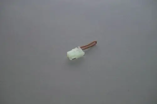 Brötje Brückenstecker mit einem transparenten Gehäuse und einem braunen Kabel. Der Stecker ist klein und besitzt eine geformte Verbindung für Elektroinstallationen.