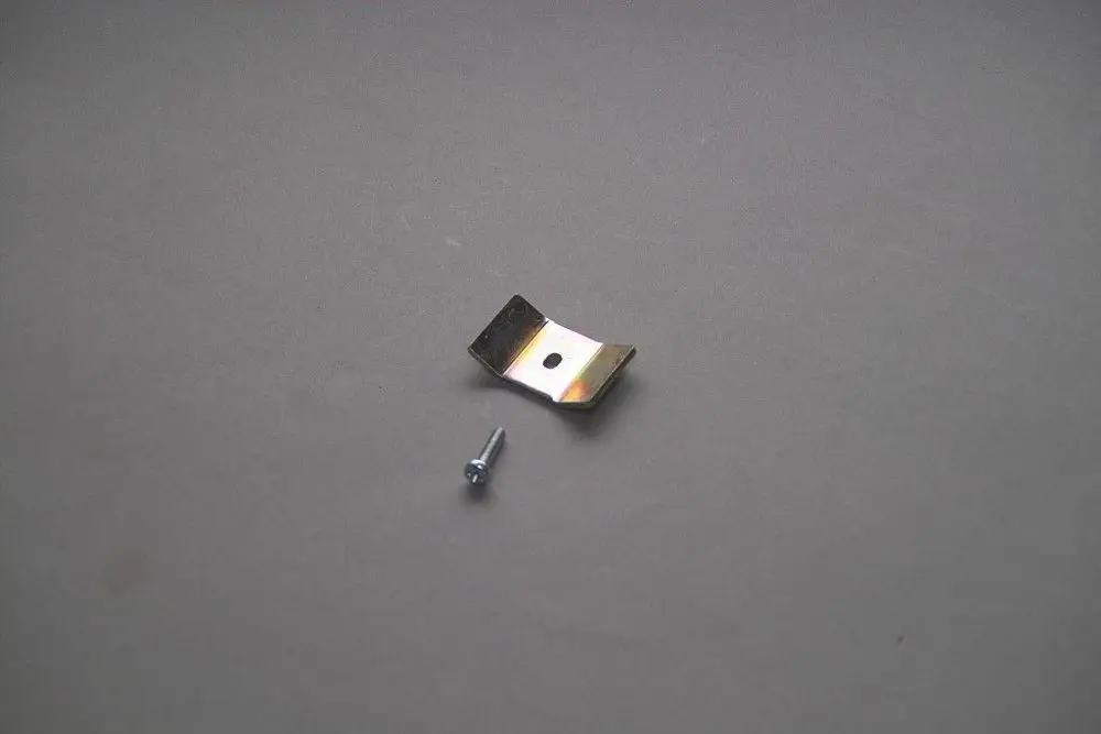 Metallischer Halter mit einer Bohrung und einer Schraube, geeignet für Brötje Produkte. Auf neutralem Hintergrund abgebildet.