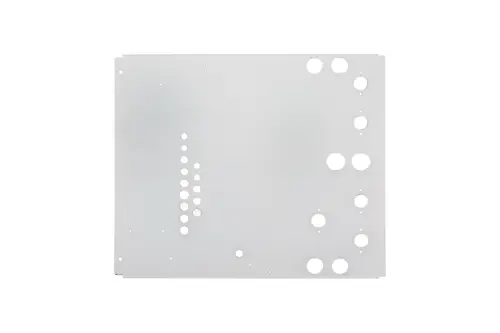 Brötje Verkleidungsdeckel aus Metall mit mehreren runden und ovalen Ausschnitten, auf einer hellen Fläche angeordnet.