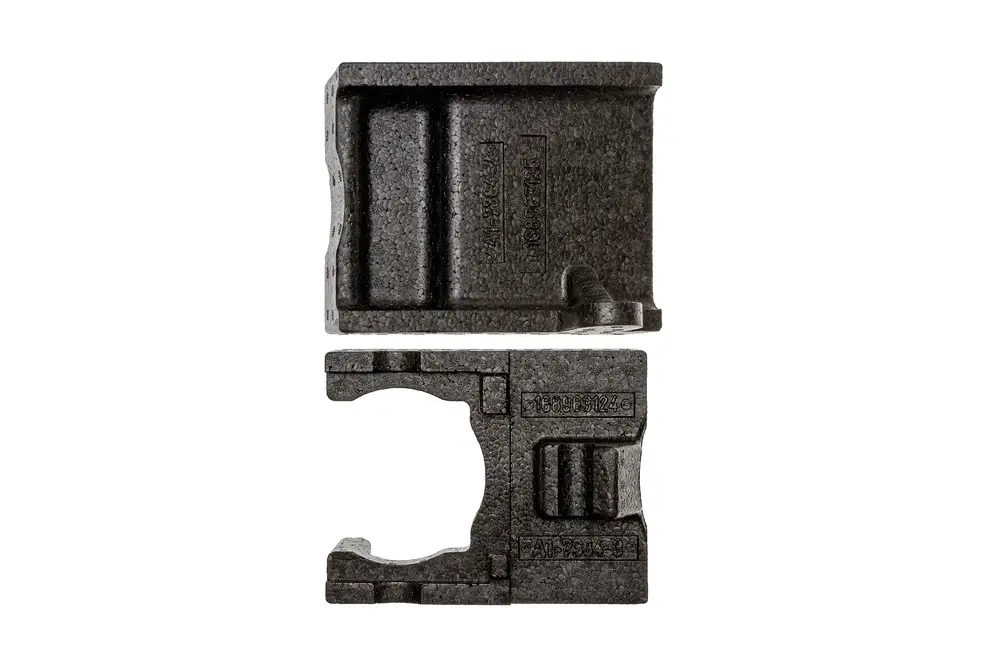 Brötje Pumpenabdeckung aus schwarzem Material, bestehend aus zwei Teilen, mit verschiedenen Vertiefungen und Beschriftungen auf der Oberfläche.