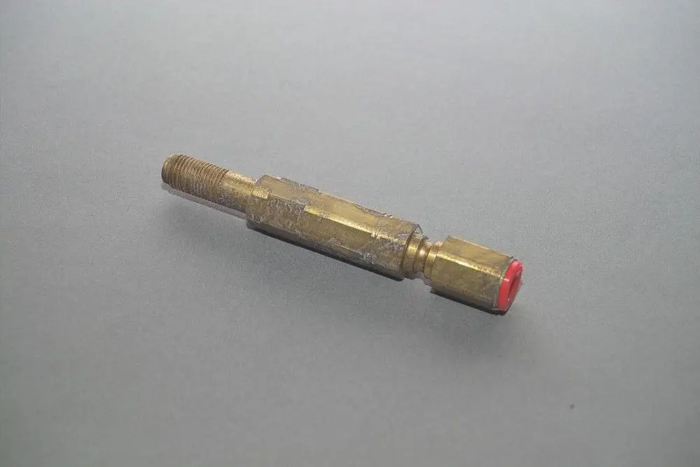 Brass component with threads on one end and a red cap on the other, resembling a part from the Brötje heating system.