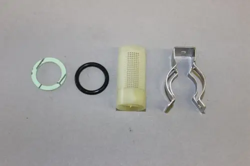 Brötje Filtereinsatz mit zwei Dichtungen, einem Kunststofffilter und einem metallenen Halteclip, angeordnet auf grauem Hintergrund.
