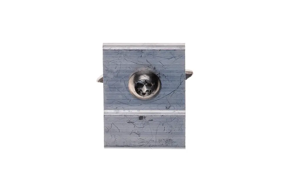 Brötje Stutzen aus Metall mit einer zentralen Schraube, die auf einer geraden Oberfläche montiert ist. Das Produkt zeigt Gebrauchsspuren und eine einfache Bauform.