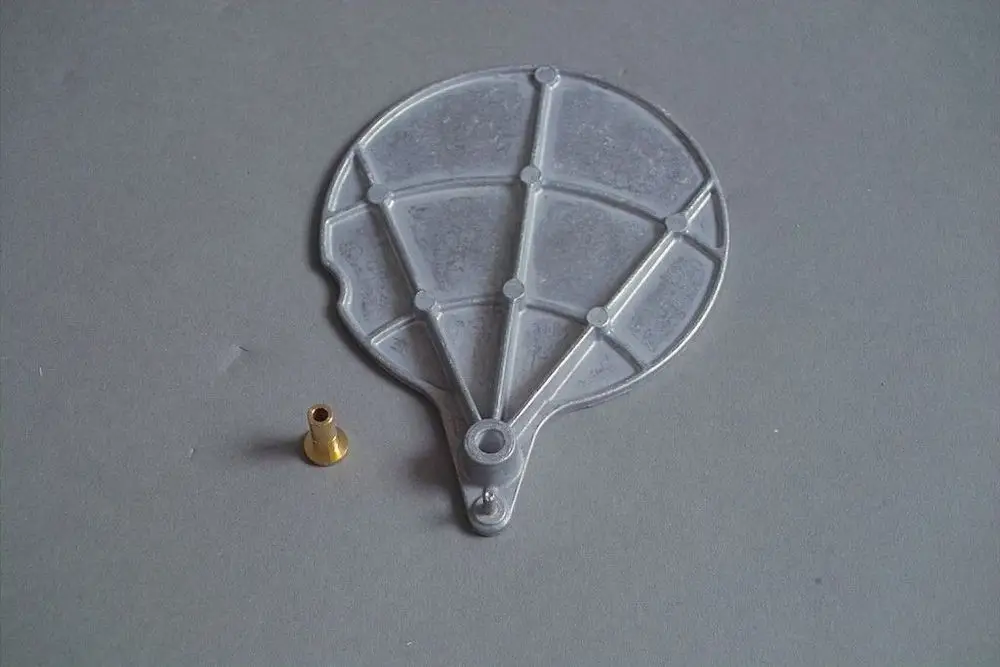 Brötje Luftklappe in Form eines flachen, runden Elements aus transparentem Material mit einem goldfarbenen Anschlussstück.