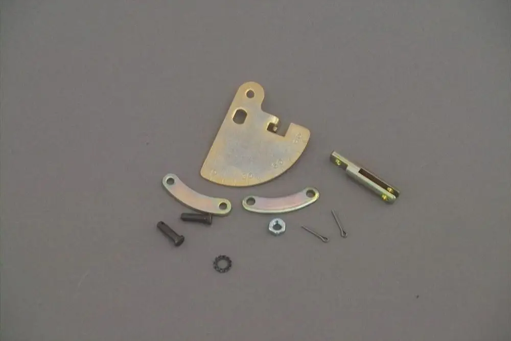 Bauteile eines Brötje-Produkts, bestehend aus metallischen Segmenten, Schrauben und Unterlegscheiben, auf grauem Untergrund angeordnet.