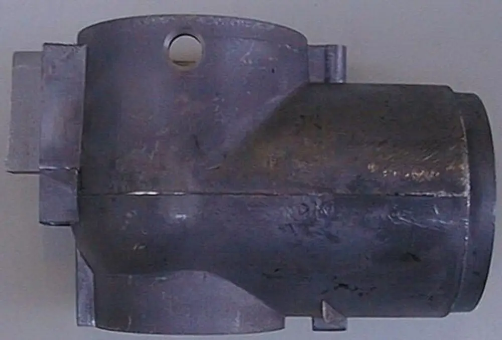 Brötje Teil, metallisch, zylindrische Form mit seitlichem Anschluss und Loch, zeigt eine einfache Bauweise, möglicherweise für Heizungsanlagen oder ähnliche Systeme.