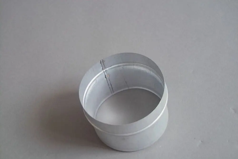 Adapter von Brötje, zylindrisch und aus Metall, mit einem durchgehenden Rand und einer nahtlosen Form. Auf grauem Untergrund abgebildet.