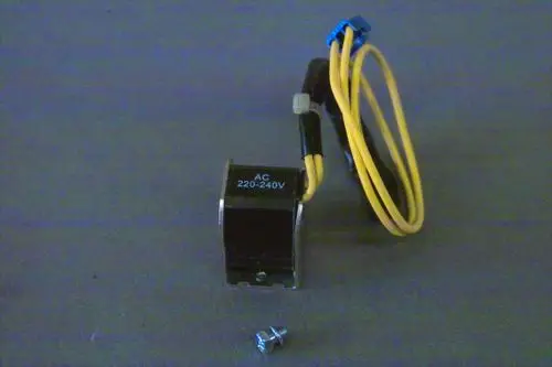 Brötje Magnetventil in schwarzer Ausführung mit Kabelanschlüssen in Gelb und Blau sowie einer Schraube im Vordergrund auf grauem Hintergrund.
