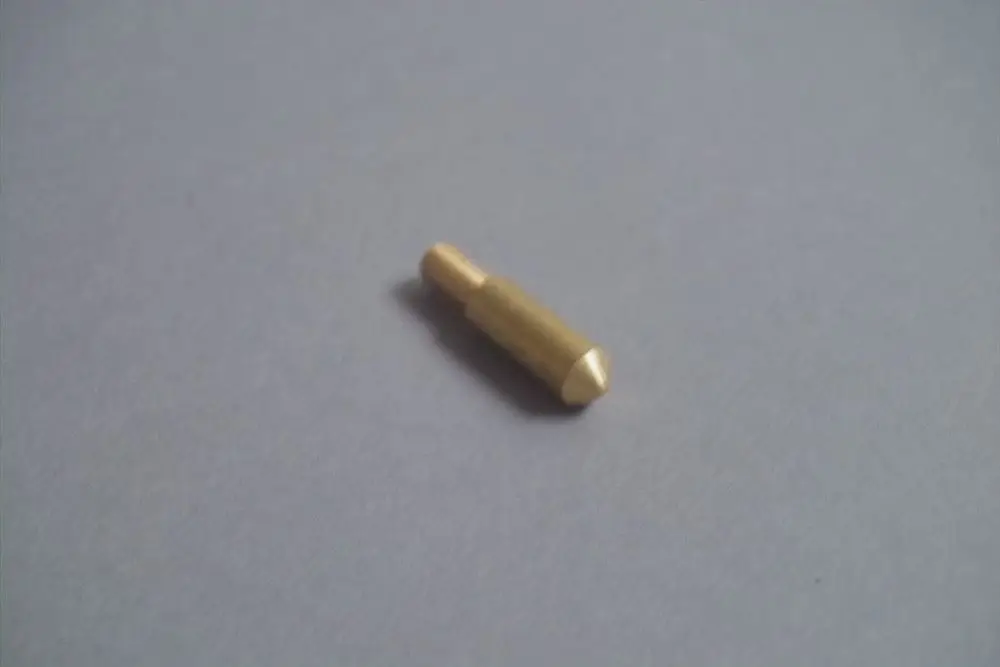 Brötje Führungsnippel aus Messing, zylindrische Form mit gezielt abgeschrägter Spitze, auf grauem Untergrund liegend.