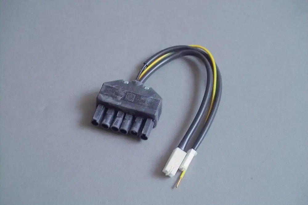 Brötje Anschlusskabel mit einem Stecker, der mehrere Pins enthält, und zwei weiteren Drähten in verschiedenen Farben, auf einem grauen Hintergrund.