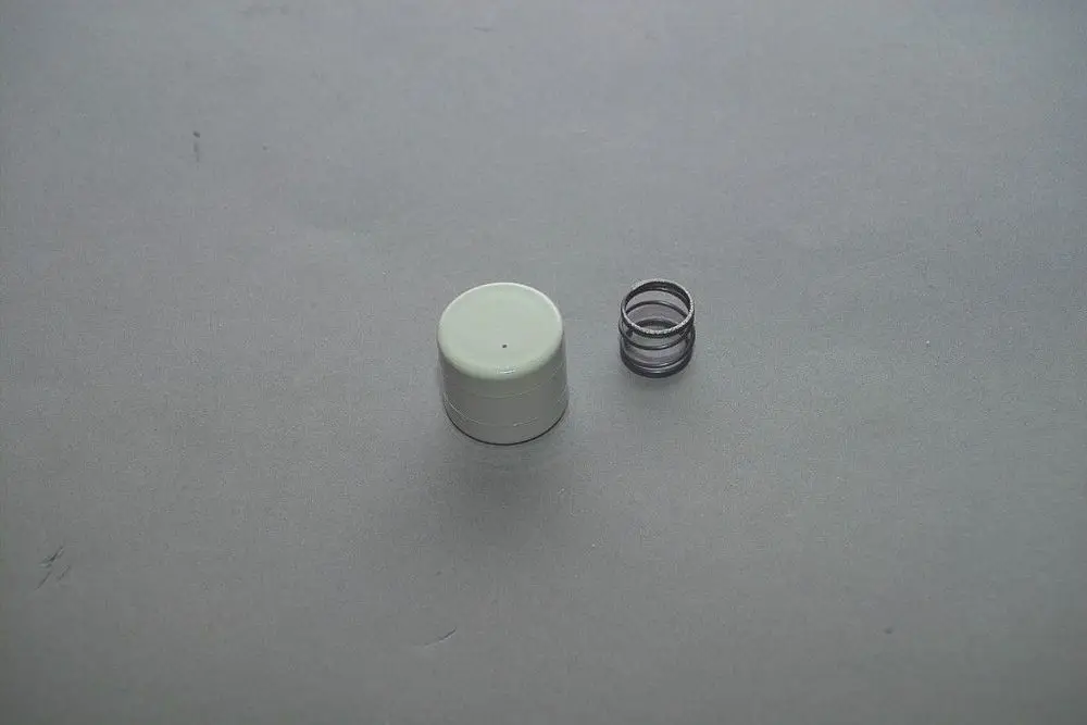 Weißer Zylinder mit flachem Deckel und transparentem Ring daneben. Produktelement von Brötje zur Verwendung in technischen Anwendungen.
