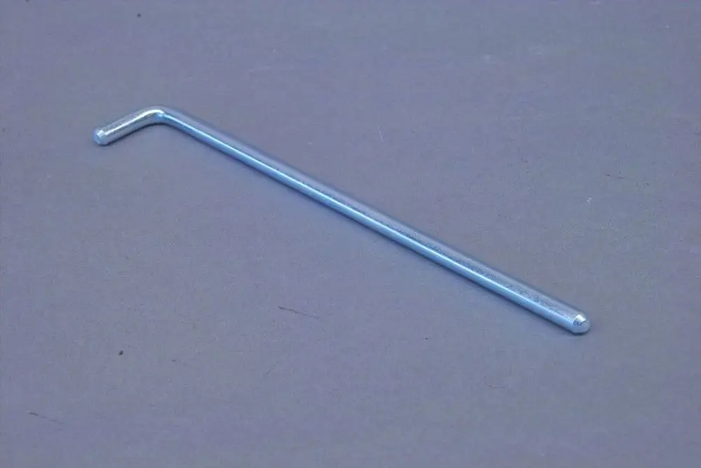 Ein metallischer, verchromter L-förmiger Stift, wie er oft in Türscharnieren verwendet wird und potenziell zur Montage in Brötje-Produkten dient.