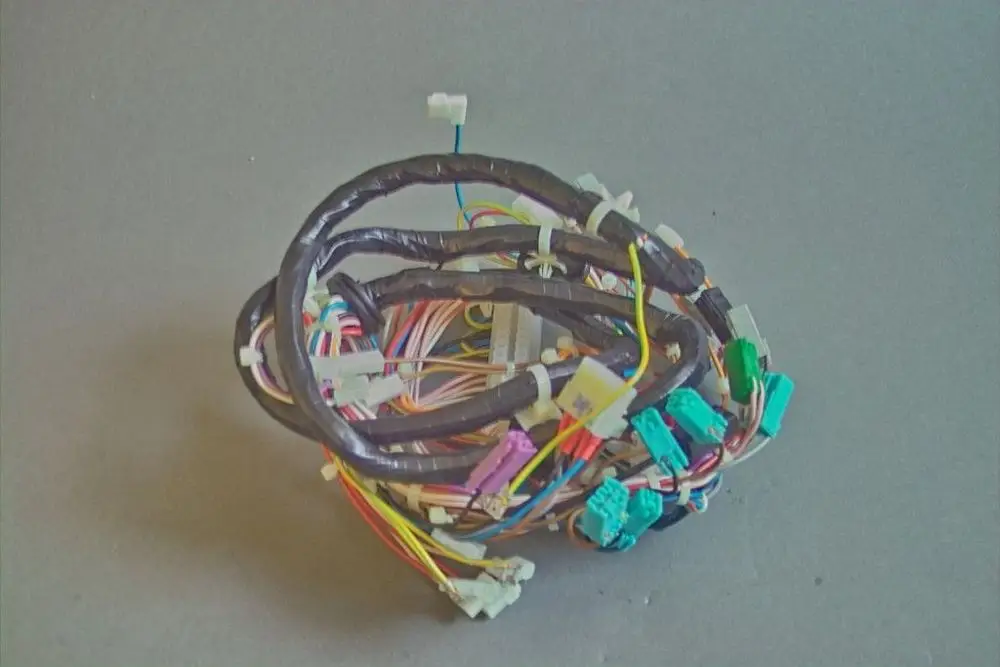 Kabelbaum von Brötje, stark verdrahtet mit mehreren farbigen Drähten und Steckverbindern. Die Kabel sind in einer kompakten Form angeordnet.