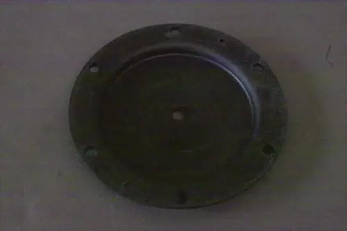 Emaillierter Deckel von Brötje, runde Form mit mittigem Loch und mehreren Befestigungsbohrungen. Oberfläche zeigt Gebrauchsspuren.