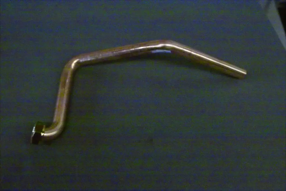 Kupferrohr mit einem gebogenen Ende und einem Anschluss, möglicherweise Teil eines Warmwassersystems von Brötje.