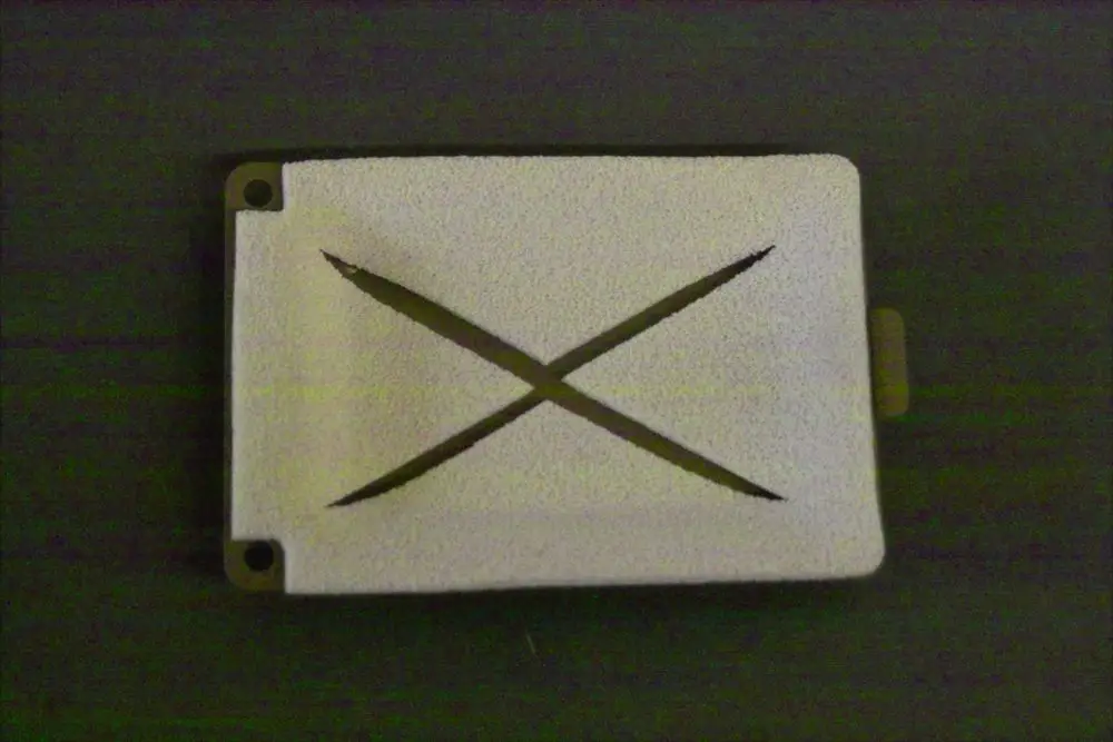 Weißes, flaches Stück mit zwei diagonalen Schlitzen in der Mitte, vermutlich eine Abdeckung für einen Wartungszugang, markiert mit "Brötje".