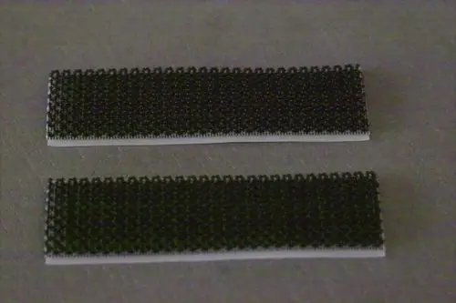 Zwei schwarze Klettstreifen auf einer grauen Oberfläche, deutlich erkennbar, ideal für Anwendungen von Brötje zur Befestigung oder Montage.