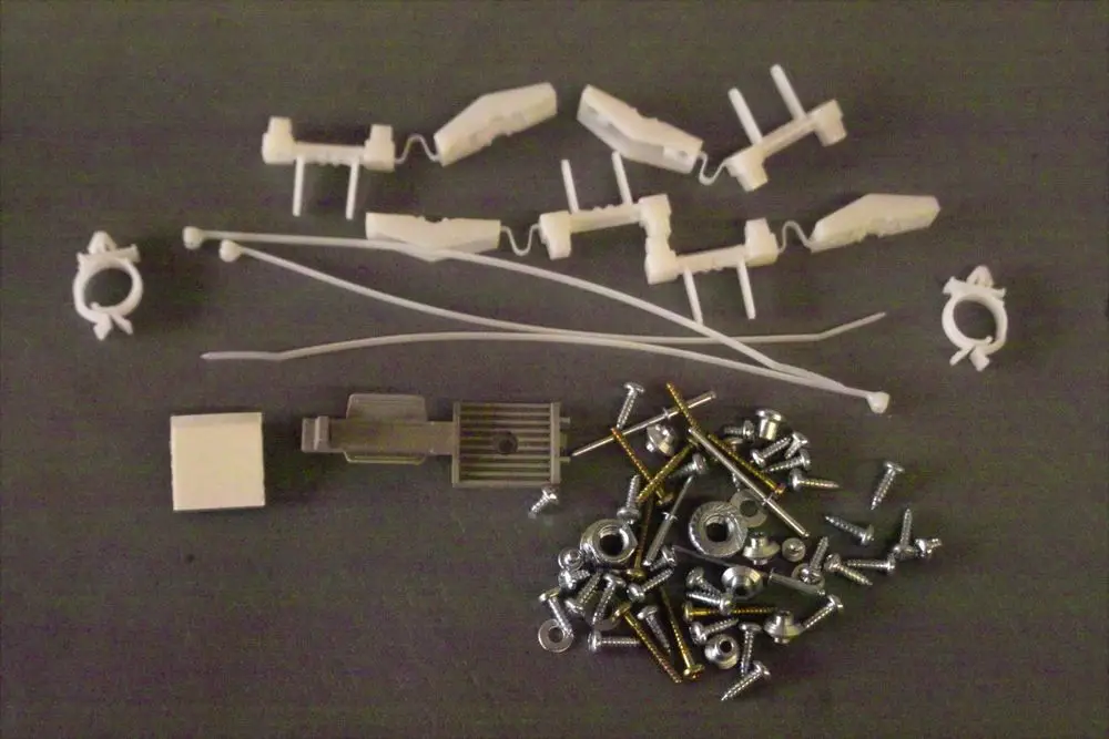 Brötje Schrauben-Set mit verschiedenen Kunststoff- und Metallteilen, einschließlich Schrauben, Unterlegscheiben und Kunststoffclips, auf grauem Hintergrund angeordnet.