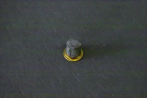 Kleiner runder Brötje-Filter mit feinem Netz und goldenem Rand auf schwarzem Hintergrund.