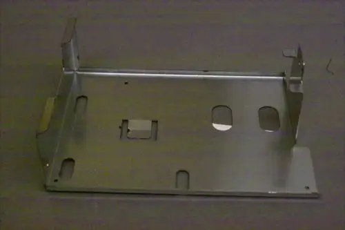 Metallischer Träger von Brötje mit mehreren Ausschnitten und Befestigungsmulden. Geeignet für die Aufnahme von Platinen oder ähnlichen Komponenten.