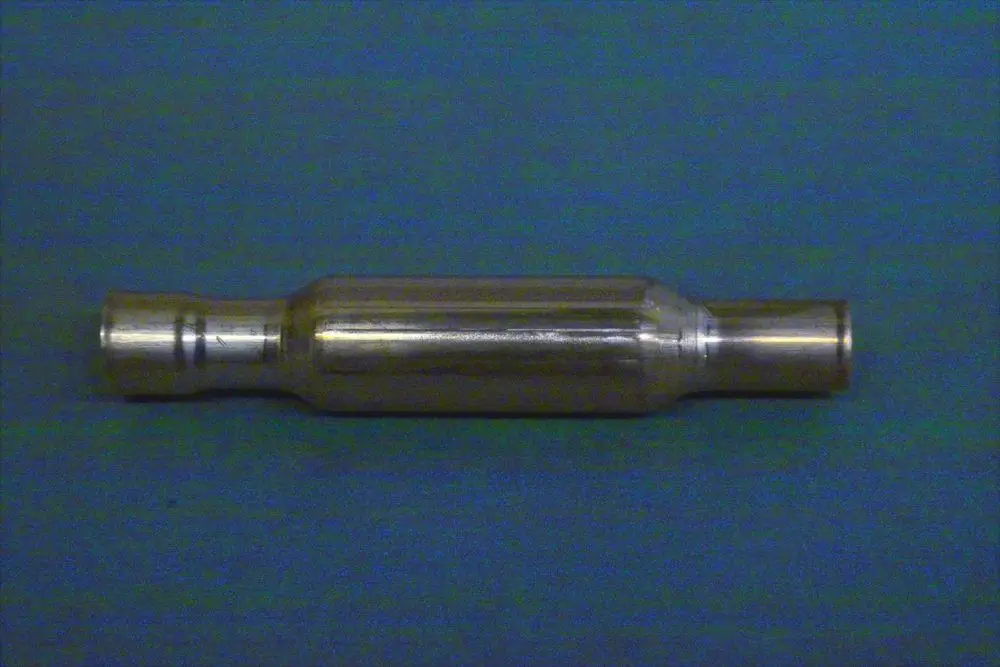 Kältemittelfilter aus Metall, zylindrische Form mit zwei Ausgängen. Produkt von Brötje, für den Einsatz in Heizungs- oder Klimaanlagen konzipiert.