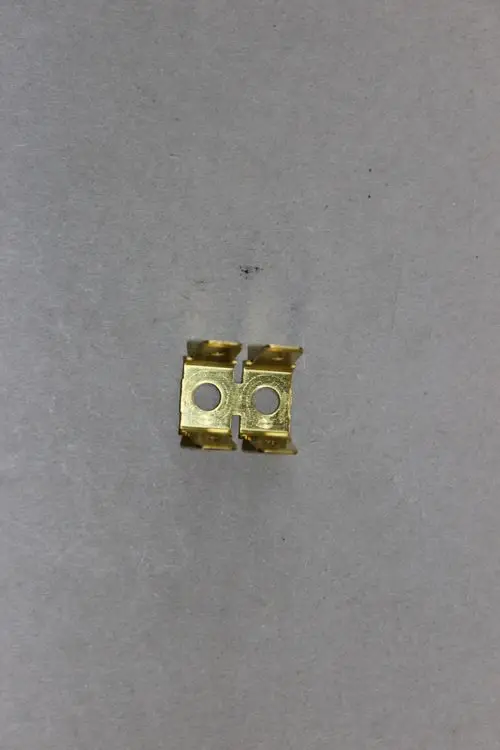 Brötje Masseleitung, zur Verbindung von elektrischen Komponenten, aus metallischem Material mit zwei kreisförmigen Öffnungen in der Mitte.