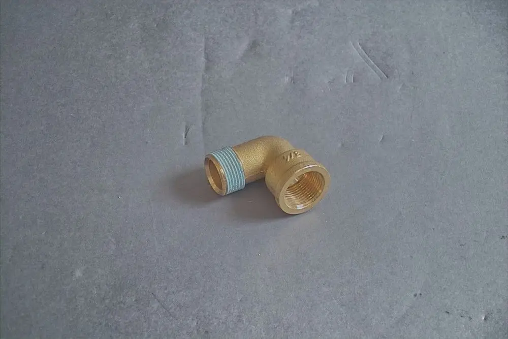 Brötje Winkel aus Messing mit einem abgewinkelten Anschluss und einem gewindedurchmesser, auf grauem Hintergrund.