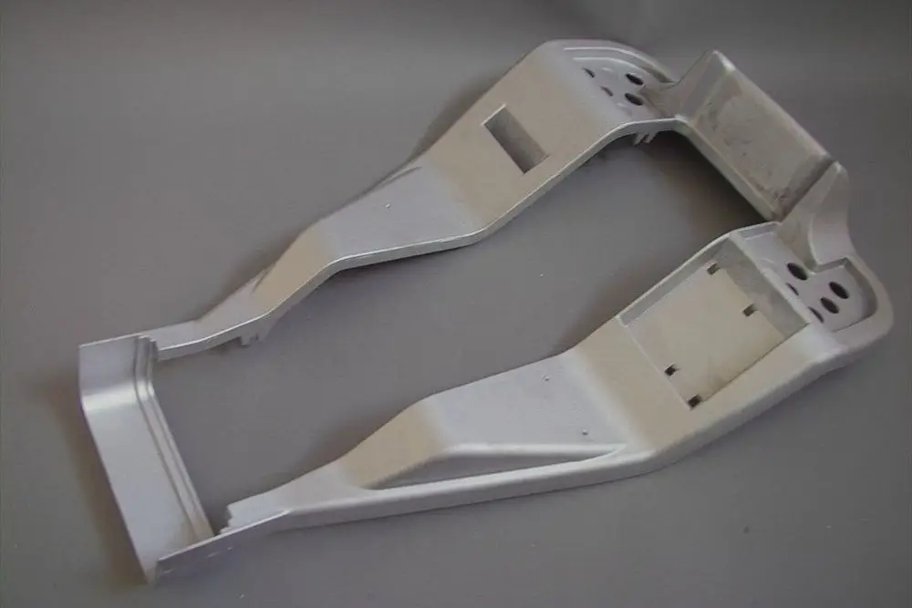 Aluminium-Grundplatte in silberner Farbe, Teil eines Heizsystems der Marke Brötje, präsentiert aus einer perspektivischen Ansicht auf grauem Hintergrund.