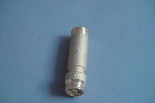 Brötje Schwerkraftsperre in silberner Ausführung, zylindrische Form mit Gewindeanschlüssen an beiden Enden, Richtungspfeil zur Kennzeichnung des Durchflusses.