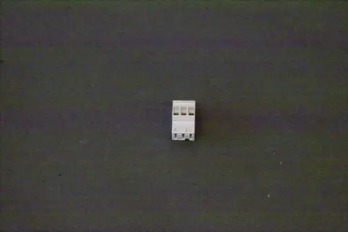 Weißer Stecker mit mehreren Anschlüssen, platziert auf einem dunklen Untergrund. Möglicherweise ein Teil von Brötje Heizungsanlagen zur Steuerung von Thermostaten.