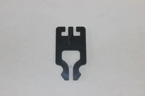 Brötje Halteklammer, flache Metallkonstruktion mit Ausstanzungen an den Seiten. Die Oberfläche ist schwarz und weist eine durchgehende Linie in der Mitte auf.