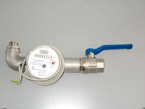 Brötje Wasserzähler mit Anschlussgewinde, Messgerät mit Zählwerk und Temperaturanzeige, verbunden mit einem Absperrventil und elektrischen Kabeln für die Messdatenerfassung.