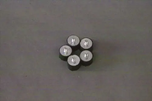 Brötje Abstandshalter in Form von fünf runden, schwarzen Pumpenhaltern mit metallischem Kopf, auf dunklem Hintergrund angeordnet.