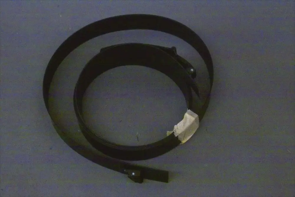 Schwarzer Spannring von Brötje, in kreisförmiger Form gewunden, mit zwei Halterungen und einem Stück Tape zur Fixierung.