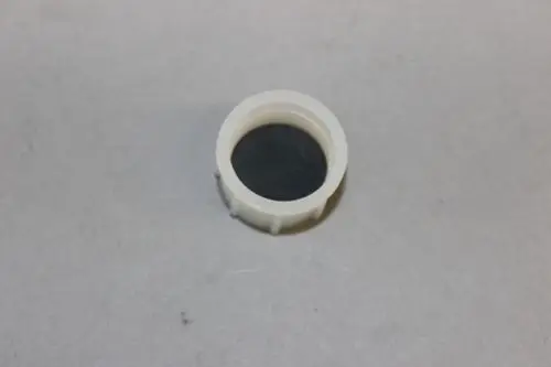 Brötje Schraubdeckel für Siphon in neutraler Farbe, runde Form mit innen liegendem schwarzen Einsatz, auf grauem Hintergrund platziert.