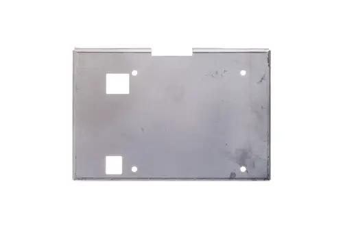 Metallplatte von Brötje, rechteckig mit zwei quadratischen Ausschnitten und mehreren Bohrlöchern. Oberfläche mit Abnutzungsspuren, ohne erkennbare Maße.