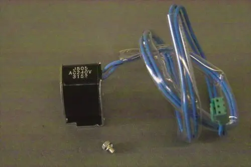 Brötje Magnetventil mit zwei blauen Drähten, einer grünen Anschlussklemme und einer Schraube. Das Ventil besitzt eine schwarze Gehäusebeschriftung.