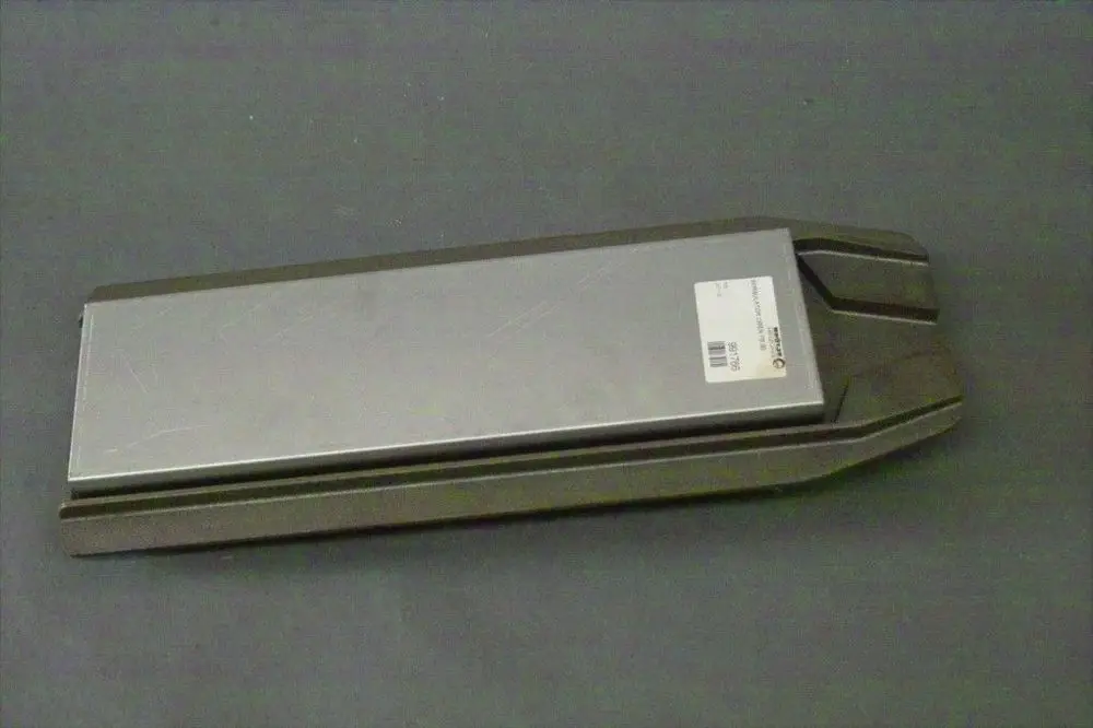 Brötje Wirbulator, flaches graues Bauteil mit einer glatten Metalloberfläche und einer Kennzeichnung auf einer Seite. Er liegt auf einem dunklen Untergrund.